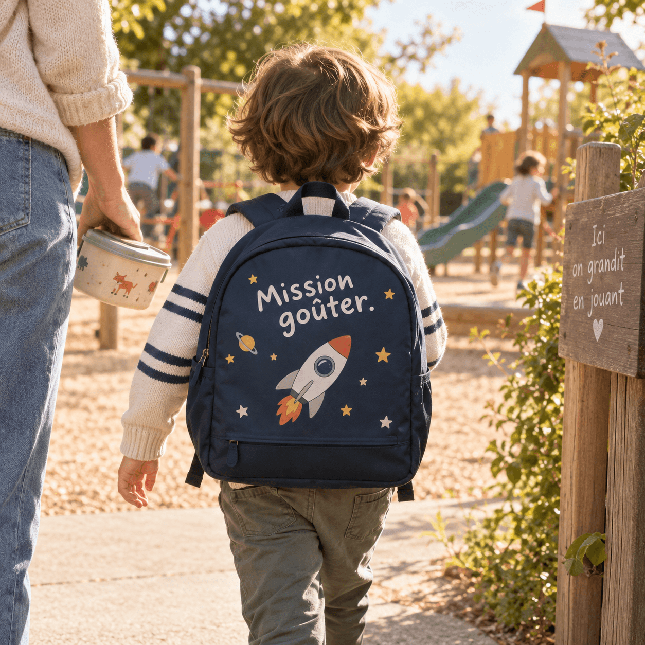 Enfant portant un sac personnalisé : « Mission goûter. »
