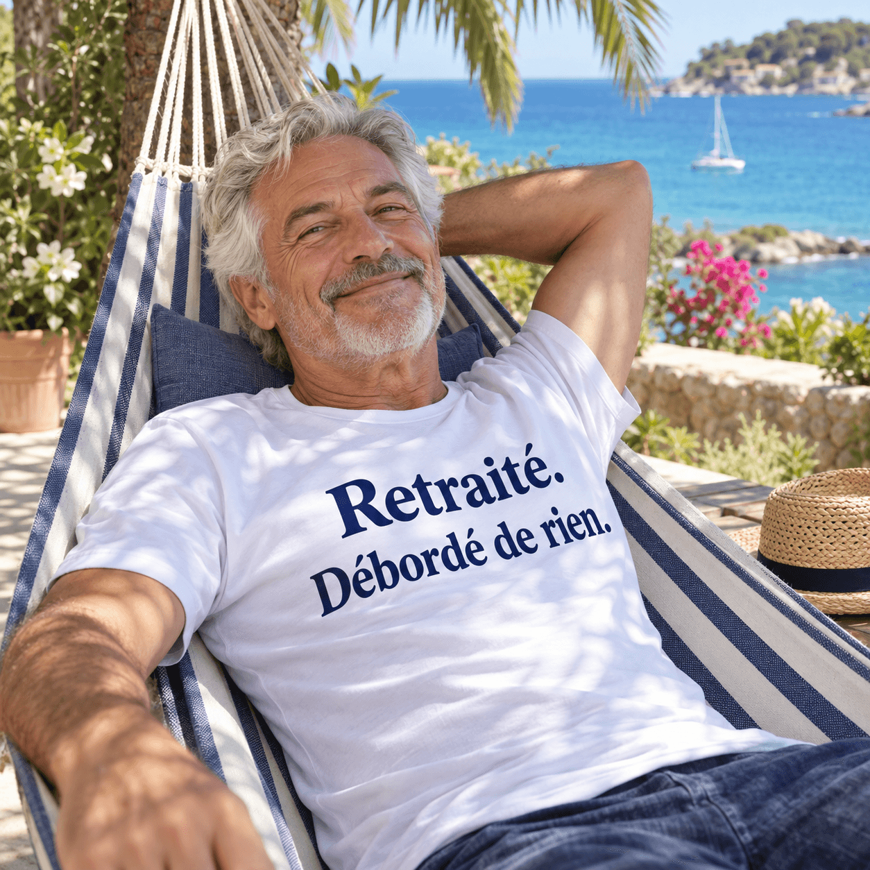 Un retraité se repose dans un hamac avec son T-shirt Retraité. Débordé de rien.