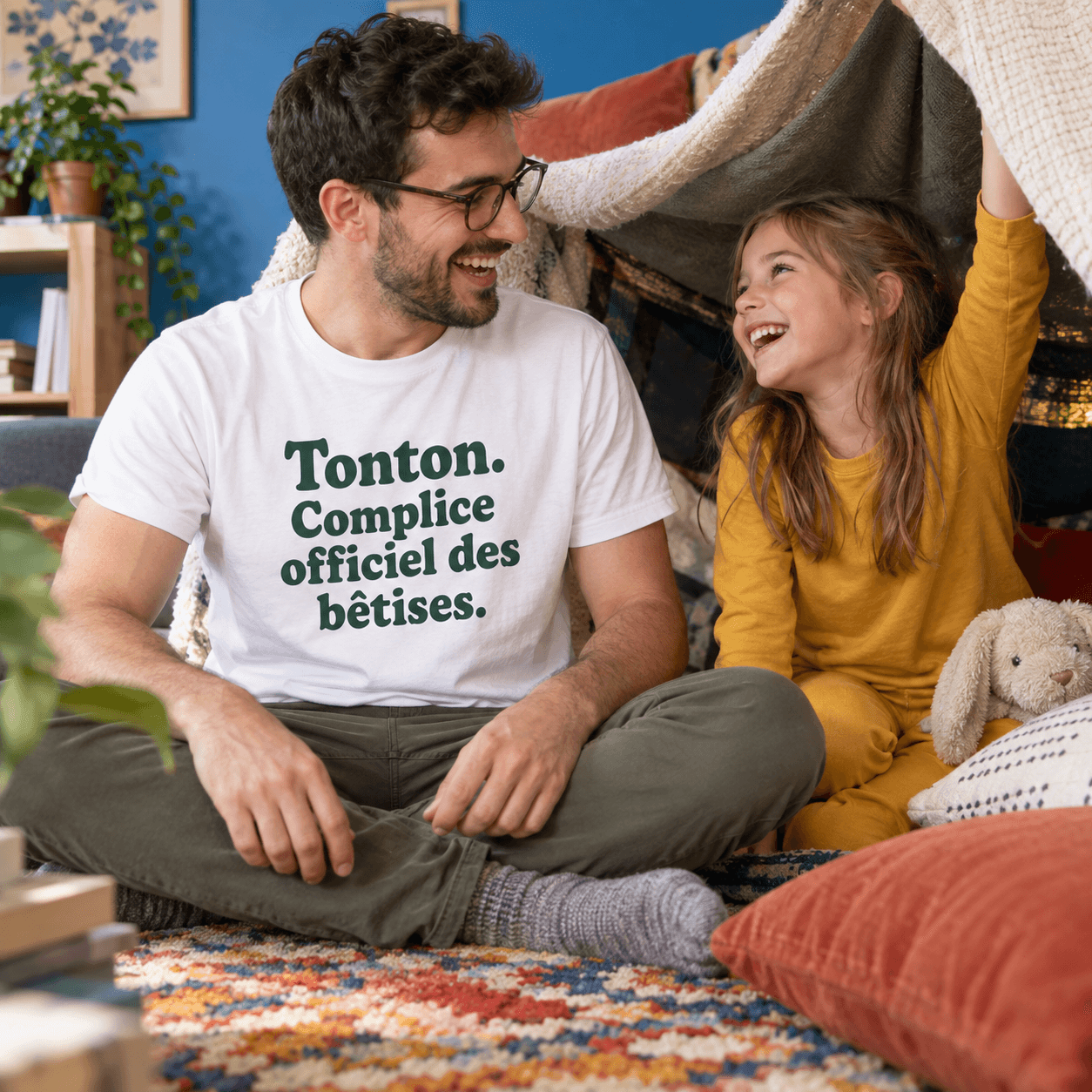 Un oncle joue avec sa nièce, son T-shirt porte Tonton. Complice officiel des bêtises.